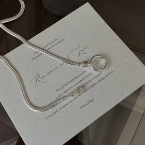 Minimalist S925 sterling silver snake chain necklace with round buckle on a paper prop