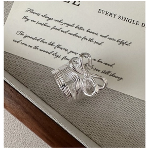 Detailed view of S925 silver bow ring with vertical texture and sparkling zircon stone