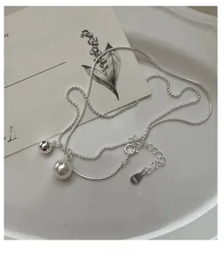 Close-up of S925 sterling silver stamp on dual-layer necklace with shell pearl