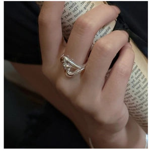 Close-up of a minimalist S925 sterling silver heart-shaped wave ring worn by a model