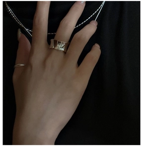 Détail d'une bague en argent S925 avec design ondulé et finition polie miroir