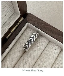 Macro shot of S925 silver wheat ear ring with vintage finish in a wooden jewelry box