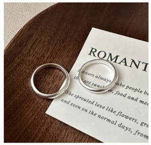 Detailed view of matte frosted S925 sterling silver rings on a wooden tray