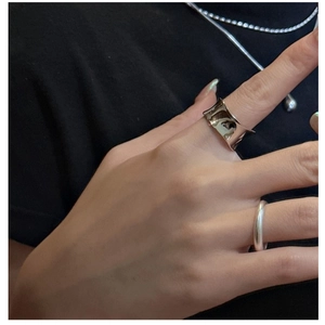 Détail de la bague large en argent effet métal liquide avec texture irrégulière au doigt