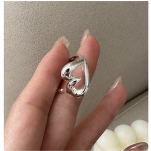 Close-up of minimalist S925 sterling silver hollow heart ring on finger for women