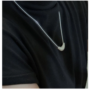 Close-up of minimalist S925 sterling silver curved bar necklace on a black crewneck shirt