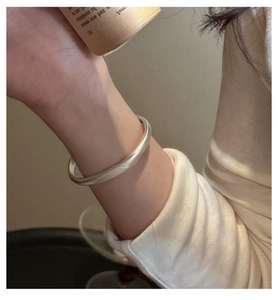 Elegant lifestyle shot of a minimalist S925 sterling silver matte solid cuff bracelet