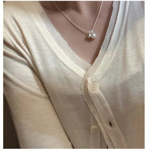 Detail of S925 silver necklace featuring a white pearl and polished metallic ball pendant