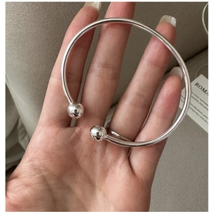 Detail eines S925 Sterling Silber Manschettenarmbands mit zwei glatten Metallkugeln