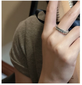 Detail of S925 sterling silver wheat ear ring with vintage texture on finger
