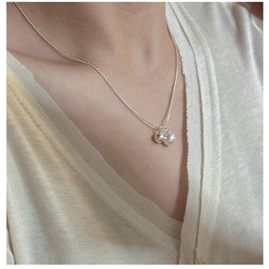 Detailed close-up of S925 silver necklace with minimalist pearl and metal bead charms