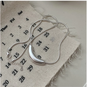 Detailed view of S925 sterling silver stamp on a matte curved snake chain necklace