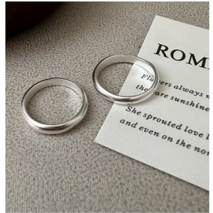 Macro detail of two minimalist S925 sterling silver rings with matte frosted texture finish
