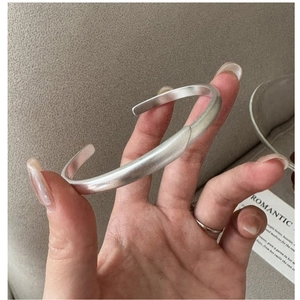 Detail of matte silver twisted cuff bracelet with minimalist brushed texture finish