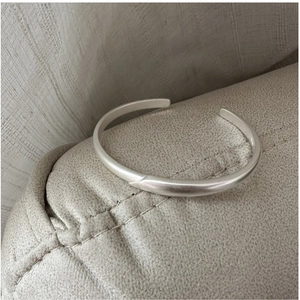 Detail of S925 sterling silver stamp on minimalist matte finish open cuff bracelet