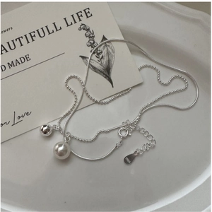 Detail of S925 sterling silver layered chain with pearl and metal ball pendants