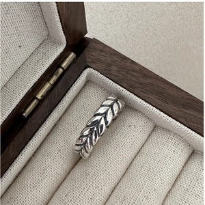 Detail of vintage S925 silver ring featuring oxidized wheat pattern in a wooden box