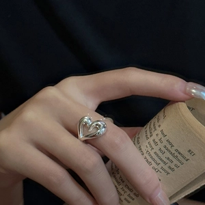 Minimalist S925 sterling silver heart-shaped ring on index finger with vintage aesthetic