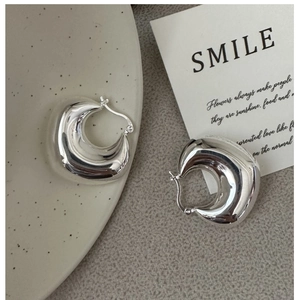 Macro detail of S925 sterling silver hollow moon earrings with polished finish and hallmark