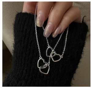 Close-up of interlocking double heart pendant in polished S925 sterling silver style