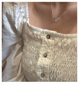 Detail view of interlocking silver double heart pendants on a delicate chain necklace