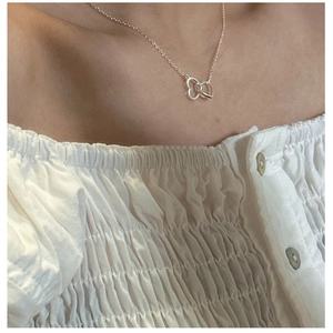 Detail of S925 sterling silver interlocking heart necklace on a model neck