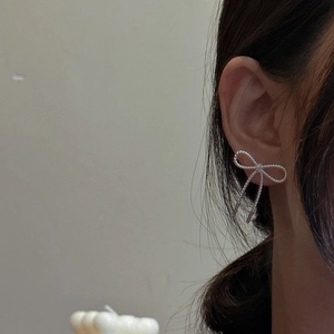 S925 sterling silver bow knot stud earrings with twisted rope texture worn by a model