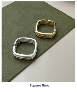 Macro shot of minimalist gold and silver multilayer square open rings in high-shine finish