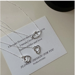 Detail of interlocking heart pendants on delicate S925 sterling silver chain necklace