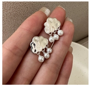 Detailed view of S925 silver cloud earrings featuring hammered texture and white pearls