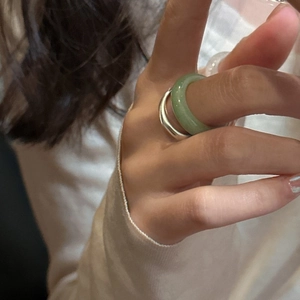 Detail of Korean style light green natural stone ring and silver band set on finger