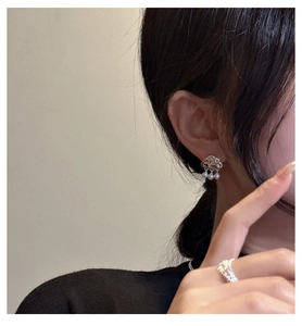 Detail of S925 silver cloud earrings with pearls and a sparkling pavé ring on a model