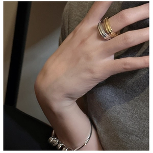Close-up of minimalist layered S925 sterling silver rings worn on a hand
