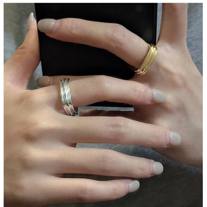 Detail of gold and silver layered wavy rings showcasing unique stacked metal texture
