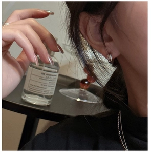 Close-up of minimalist silver hoop earrings worn by a model in a refined setting