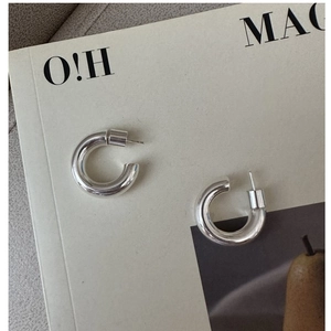 Macro shot of minimalist S925 sterling silver hoop earrings with a high-polished mirror finish