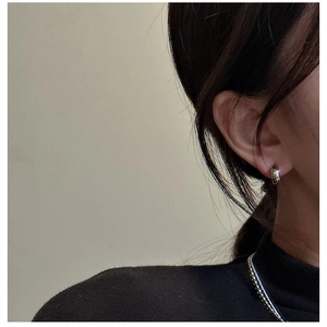 Close-up of minimalist S925 sterling silver hook earrings worn on a model's ear