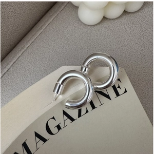 Close-up of chunky S925 sterling silver C-shaped hoop earrings with mirror polished finish