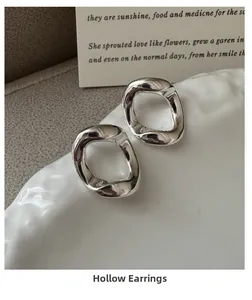 Vue détaillée de boucles d'oreilles creuses en argent S925 avec texture de métal liquide fluide