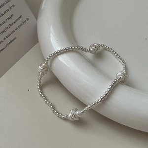 Bracelet élégant en argent sterling S925 avec perles sur une assiette en céramique blanche