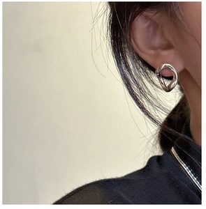 Gros plan de boucles d'oreilles géométriques argentées portées par un mannequin