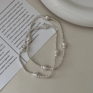 Bracelet minimaliste en argent sterling S925 avec perles blanches sur fond beige