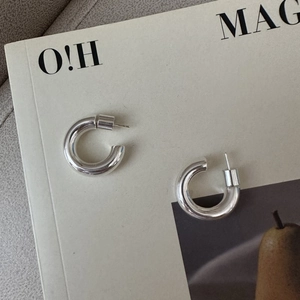 Polished S925 sterling silver hoop earrings displayed on a minimalist fashion magazine