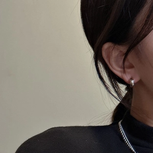 Minimalist S925 sterling silver hoop earrings worn by a model in a side profile shot