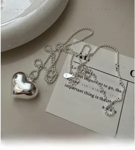 Detailed close-up of S925 sterling silver hollow heart pendant on a stylish bead chain