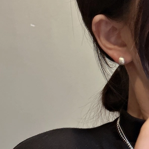 S925 sterling silver teardrop studs with brushed finish worn by a model in minimalist style