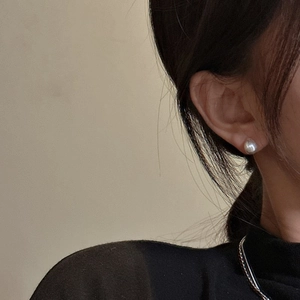 Elegant S925 sterling silver pearl stud earrings with minimalist design on female model