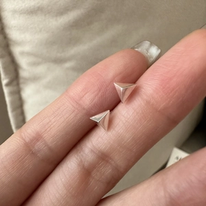 Nahaufnahme minimalistischer S925 Sterlingsilber Dreieck Ohrstecker auf den Fingern