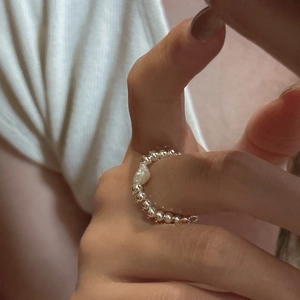 Detailed close-up of a handmade S925 silver beaded ring with a baroque pearl on a finger