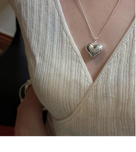 Detailed view of 3D hollow heart pendant necklace in polished S925 sterling silver on model